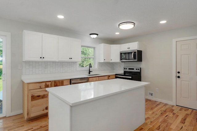 7208 N Farm Rd Unit 133, Springfield, MO 65803 - kitchen featuring appliances with stainless steel finishes, backsplash, light wood-style floors, white cabinets, and recessed lighting