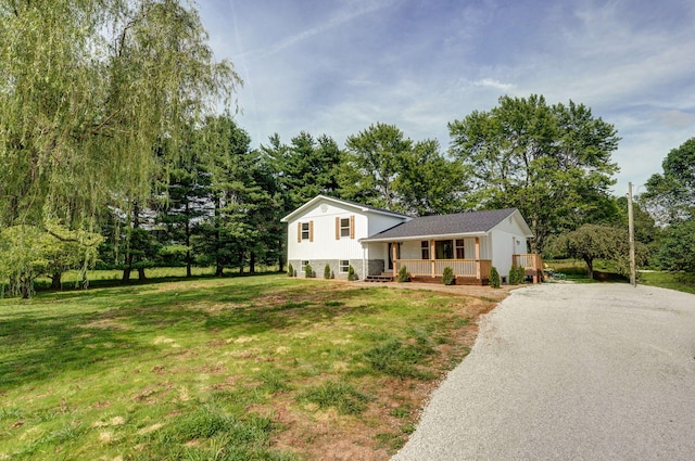 7208 N Farm Rd Unit 133, Springfield, MO 65803 - tri-level home with gravel driveway, a porch, a front yard, and view of scattered trees