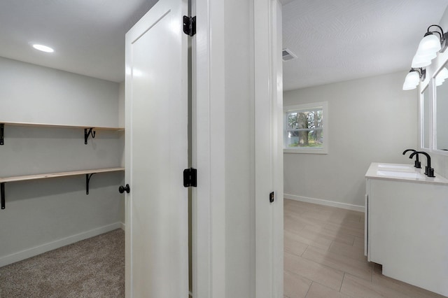 7208 N Farm Rd Unit 133, Springfield, MO 65803 - bathroom with vanity, a walk in closet, and recessed lighting