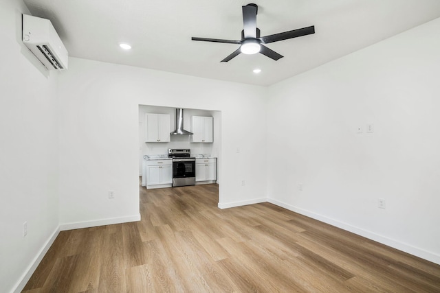 934 S New Ave, Springfield, MO 65806 - unfurnished living room with a wall unit AC, a ceiling fan, light wood-style flooring, and recessed lighting