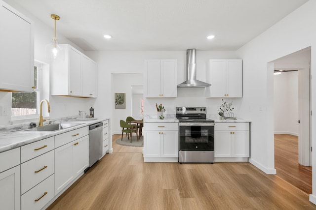 934 S New Ave, Springfield, MO 65806 - kitchen with appliances with stainless steel finishes, wall chimney range hood, light wood-style floors, white cabinetry, and recessed lighting