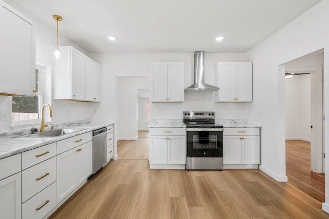 934 S New Ave, Springfield, MO 65806 - kitchen with stainless steel appliances, wall chimney exhaust hood, light wood-style flooring, white cabinets, and recessed lighting