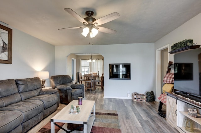 1908 Hazel St, Carthage, MO 64836 - living room featuring wood finished floors, arched walkways, ceiling fan, and a chandelier