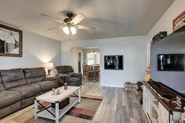 1908 Hazel St, Carthage, MO 64836 - living room with arched walkways, a ceiling fan, wood finished floors, and a chandelier