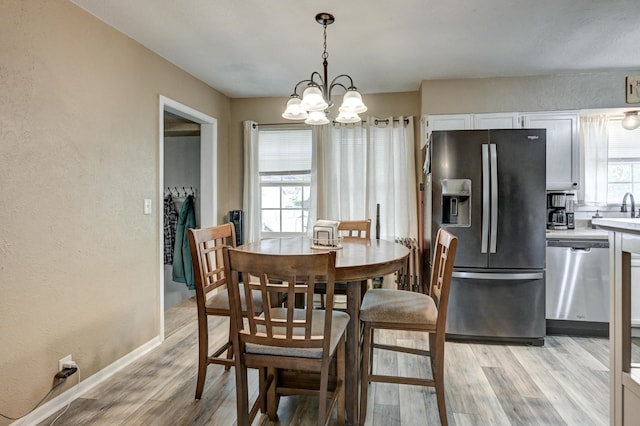 1908 Hazel St, Carthage, MO 64836 - dining area with a textured wall, light wood-style flooring, and a chandelier