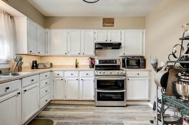 1908 Hazel St, Carthage, MO 64836 - kitchen featuring appliances with stainless steel finishes, under cabinet range hood, white cabinets, and decorative backsplash