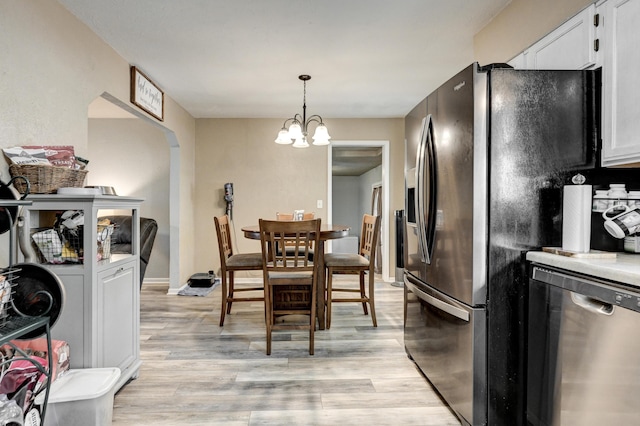 1908 Hazel St, Carthage, MO 64836 - kitchen featuring stainless steel dishwasher, fridge with ice dispenser, light wood finished floors, a chandelier, and white cabinets