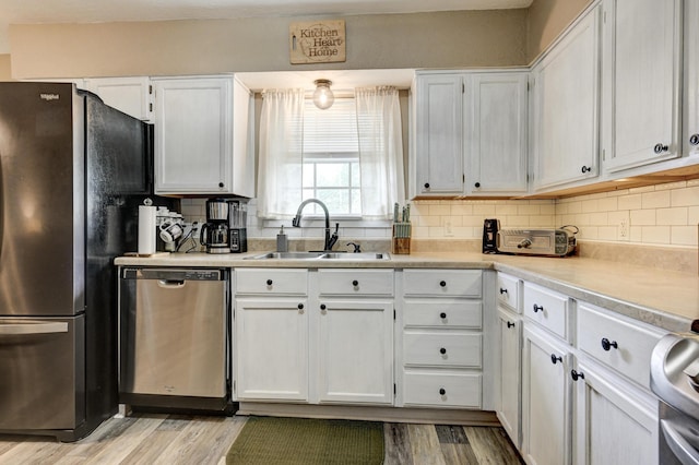 1908 Hazel St, Carthage, MO 64836 - kitchen featuring stainless steel dishwasher, freestanding refrigerator, white cabinets, and decorative backsplash
