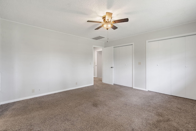 595 Johns Ford Rd, Sparta, MO 65753 - unfurnished bedroom with two closets, carpet, a textured ceiling, and a ceiling fan