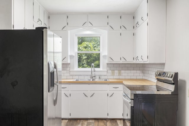 595 Johns Ford Rd, Sparta, MO 65753 - kitchen with appliances with stainless steel finishes, tasteful backsplash, light wood-style floors, and white cabinets