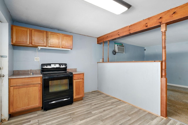 1311 S 9th St, Ozark, MO 65721 - kitchen with black electric range oven, light countertops, light wood-style flooring, a wall mounted air conditioner, and beamed ceiling