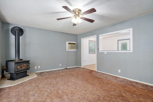 1311 S 9th St, Ozark, MO 65721 - unfurnished living room featuring an AC wall unit, ceiling fan, carpet flooring, and a wood stove