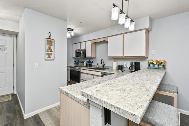 123 Bunker Ridge Dr Unit 7, Branson, MO 65616 - kitchen featuring stainless steel appliances, light countertops, wood finished floors, and a kitchen breakfast bar
