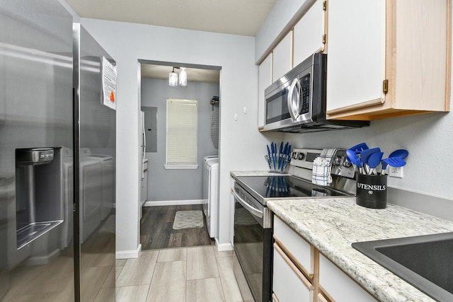 123 Bunker Ridge Dr Unit 7, Branson, MO 65616 - kitchen with appliances with stainless steel finishes, washer and clothes dryer, white cabinetry, and electric panel
