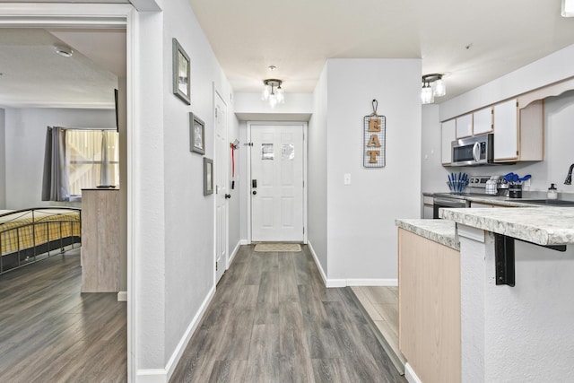 123 Bunker Ridge Dr Unit 7, Branson, MO 65616 - kitchen with stainless steel appliances, dark wood-style floors, light countertops, and a breakfast bar area