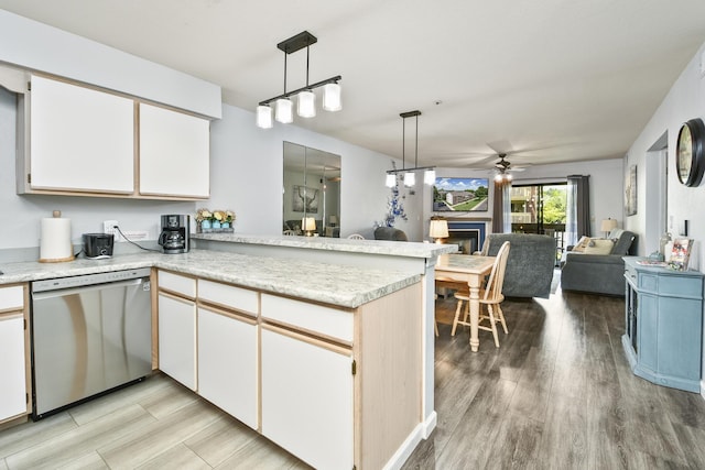 123 Bunker Ridge Dr Unit 7, Branson, MO 65616 - kitchen with dishwasher, a ceiling fan, a peninsula, a fireplace, and light countertops
