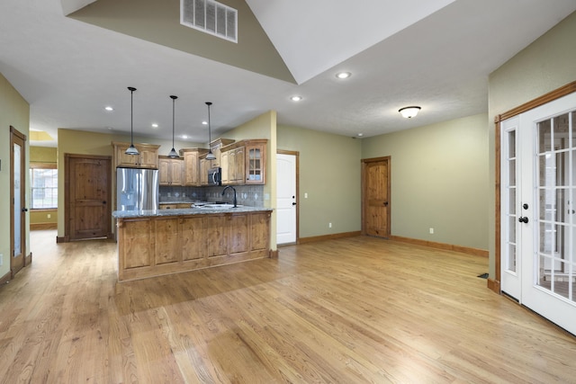 1225 W Wildcherry St, Ozark, MO 65721 - kitchen with stainless steel appliances, tasteful backsplash, brown cabinetry, light wood-style floors, and glass insert cabinets