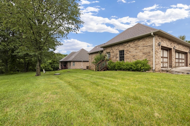 1225 W Wildcherry St, Ozark, MO 65721 - view of side of property with a yard, brick siding, an attached garage, driveway, and a shingled roof