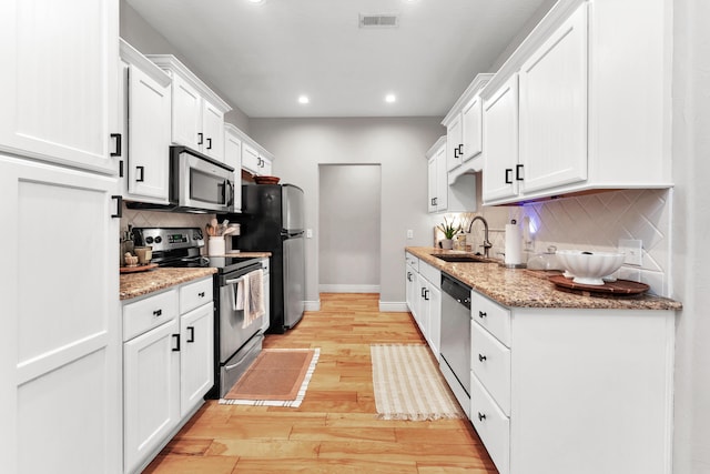 811 Gold Rush Ave, Nixa, MO 65714 - kitchen with appliances with stainless steel finishes, recessed lighting, light wood-style flooring, tasteful backsplash, and white cabinetry