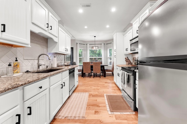 811 Gold Rush Ave, Nixa, MO 65714 - kitchen with appliances with stainless steel finishes, white cabinets, light wood finished floors, tasteful backsplash, and recessed lighting