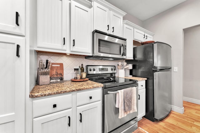 811 Gold Rush Ave, Nixa, MO 65714 - kitchen featuring appliances with stainless steel finishes, decorative backsplash, light wood-type flooring, white cabinets, and light stone countertops