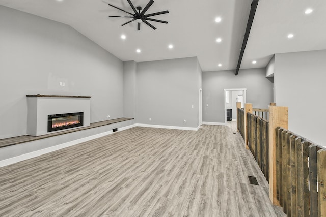 3918 Bowen Creek Rd, Niangua, MO 65713 - unfurnished living room with light wood-style flooring, a ceiling fan, recessed lighting, a glass covered fireplace, and lofted ceiling