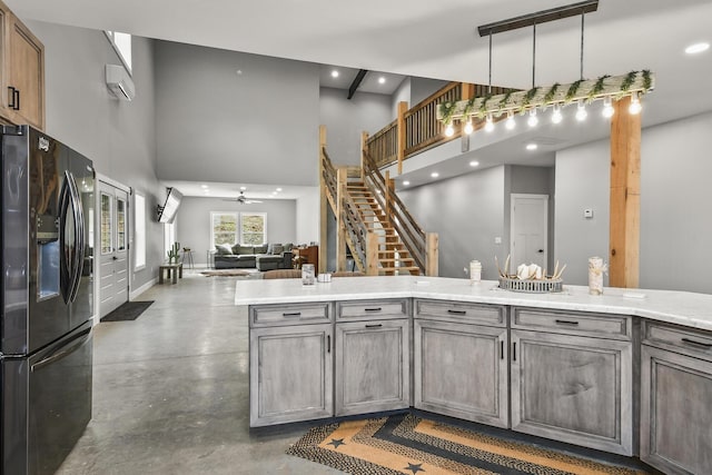 3918 Bowen Creek Rd, Niangua, MO 65713 - kitchen with black fridge, a high ceiling, an AC wall unit, concrete floors, and a ceiling fan