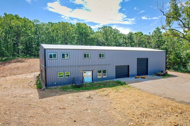 3918 Bowen Creek Rd, Niangua, MO 65713 - view of front facade with dirt driveway, a garage, and a forest view