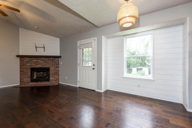 4252 W Madison St, Springfield, MO 65802 - unfurnished living room with lofted ceiling, ceiling fan, a textured ceiling, hardwood / wood-style flooring, and a brick fireplace