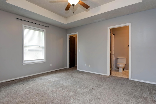 4252 W Madison St, Springfield, MO 65802 - unfurnished bedroom featuring a raised ceiling, carpet, and connected bathroom