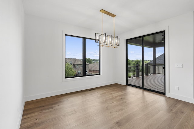 1650 Marlowe Ave, Springfield, MO 65802 - empty room featuring plenty of natural light, wood finished floors, and a chandelier