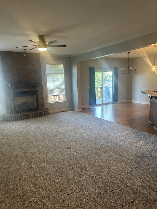 5605 N Seacrest Dr, Ozark, MO 65721 - unfurnished living room featuring carpet, a fireplace, crown molding, a ceiling fan, and a chandelier