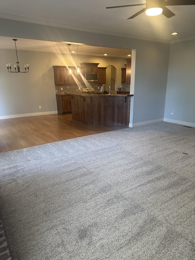 5605 N Seacrest Dr, Ozark, MO 65721 - unfurnished living room with ornamental molding, carpet flooring, ceiling fan, a chandelier, and arched walkways