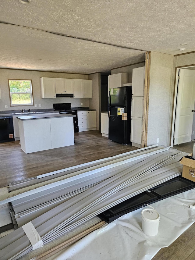 000 Oak St, Conway, MO 65632 - kitchen with black appliances, white cabinetry, under cabinet range hood, a textured ceiling, and dark wood-type flooring