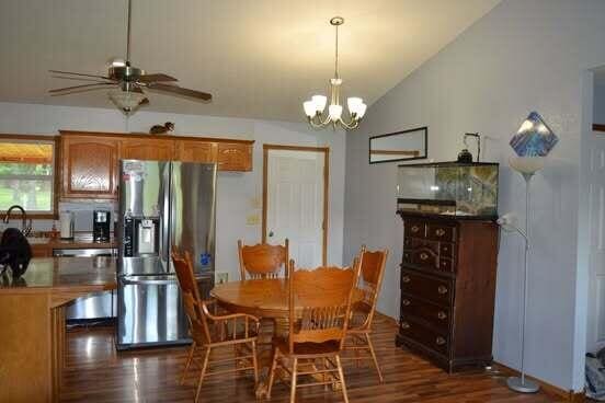 163 Hidden Hollow Dr, Marshfield, MO 65706 - dining space featuring vaulted ceiling, dark wood-style flooring, a chandelier, and ceiling fan