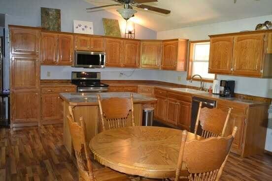 163 Hidden Hollow Dr, Marshfield, MO 65706 - kitchen featuring stainless steel microwave, stove, vaulted ceiling, a ceiling fan, and a kitchen island
