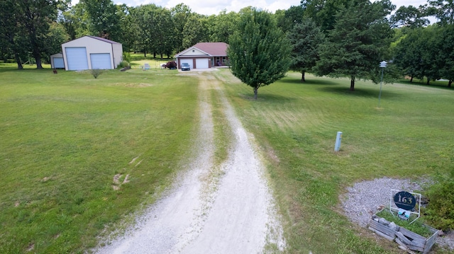 163 Hidden Hollow Dr, Marshfield, MO 65706 - view of grassy yard with a garage, dirt driveway, and an outdoor structure