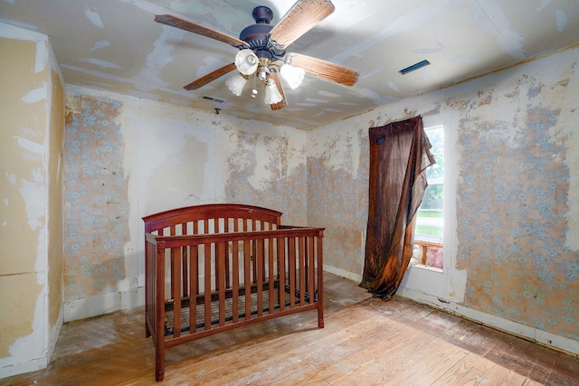 427 Morgan Ave, Aurora, MO 65605 - bedroom with wood-type flooring, ceiling fan, and wallpapered walls