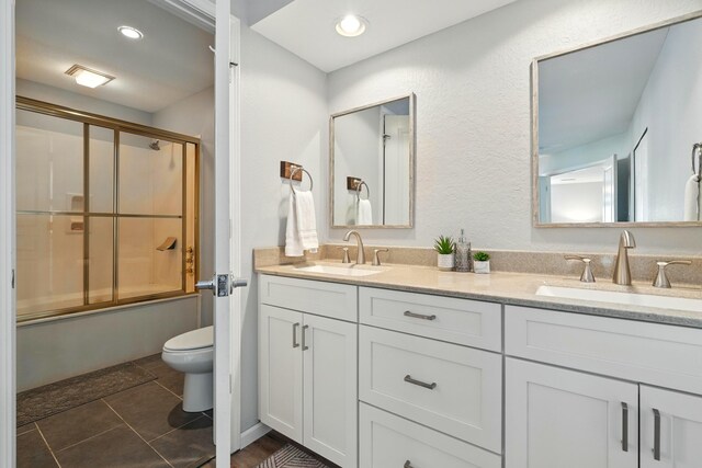 215 Meadow Brook Ln Unit 3, Branson, MO 65616 - bathroom featuring double vanity, combined bath / shower with glass door, tile patterned floors, and recessed lighting
