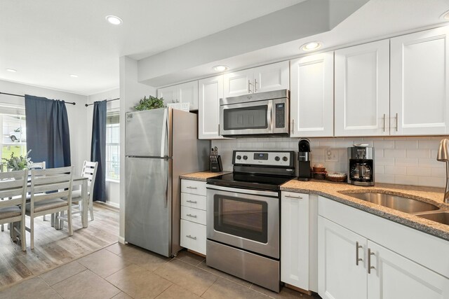215 Meadow Brook Ln Unit 3, Branson, MO 65616 - kitchen featuring stainless steel appliances, light tile patterned floors, decorative backsplash, white cabinetry, and recessed lighting
