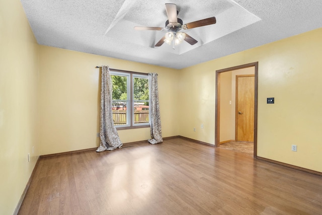 1801 W Cherokee St, Springfield, MO 65807 - unfurnished room featuring a textured ceiling, wood finished floors, ceiling fan, and a tray ceiling