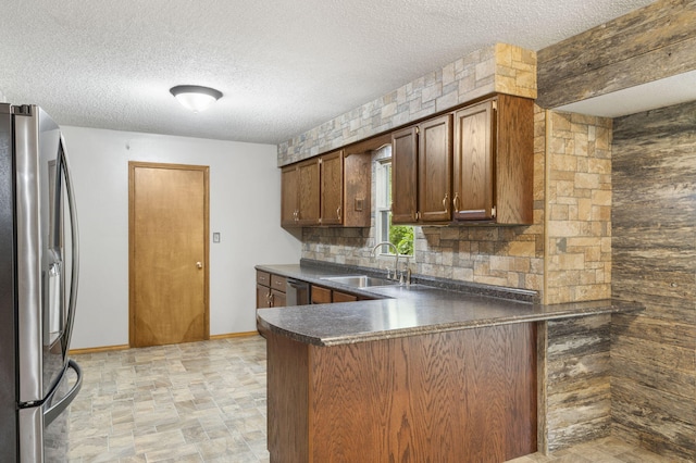 1801 W Cherokee St, Springfield, MO 65807 - kitchen featuring appliances with stainless steel finishes, a peninsula, dark countertops, a textured ceiling, and backsplash