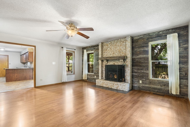 1801 W Cherokee St, Springfield, MO 65807 - unfurnished living room featuring ceiling fan, wood finished floors, a textured ceiling, and a fireplace