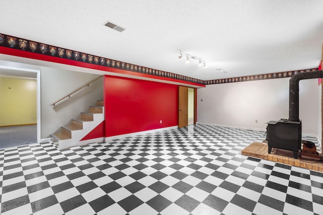 1801 W Cherokee St, Springfield, MO 65807 - finished basement with a wood stove, track lighting, stairs, and tile patterned floors