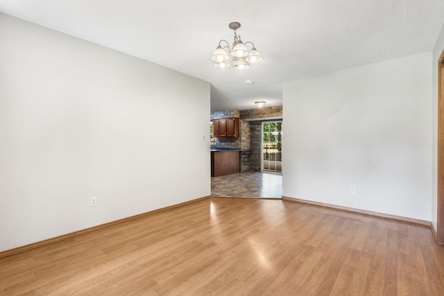 1801 W Cherokee St, Springfield, MO 65807 - unfurnished living room featuring light wood finished floors and a chandelier