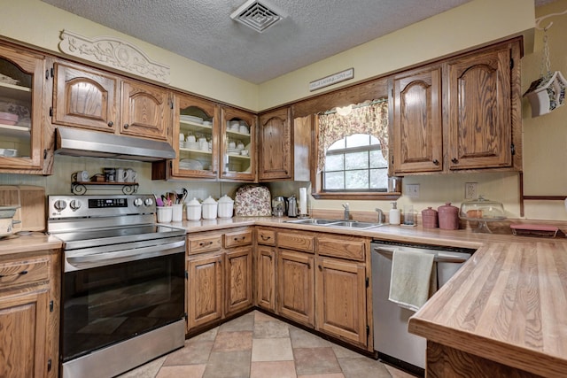 1706 Ankney Pl, Neosho, MO 64850 - kitchen featuring stainless steel appliances, under cabinet range hood, brown cabinets, light countertops, and a textured ceiling