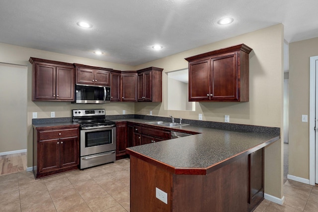 5834 Geranium Ln, Battlefield, MO 65619 - kitchen with stainless steel appliances, dark countertops, a peninsula, recessed lighting, and light tile patterned flooring