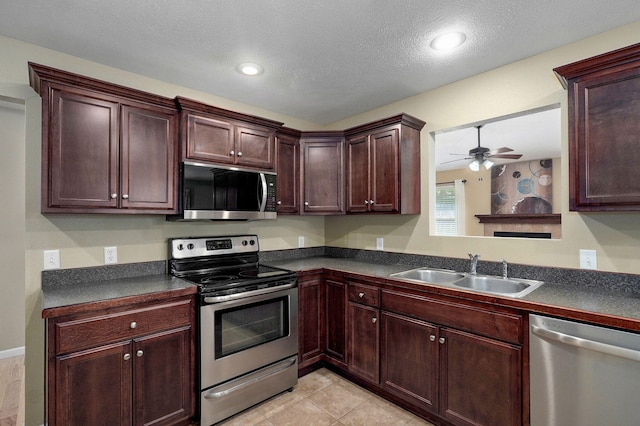 5834 Geranium Ln, Battlefield, MO 65619 - kitchen featuring appliances with stainless steel finishes, dark countertops, a ceiling fan, a textured ceiling, and light tile patterned floors