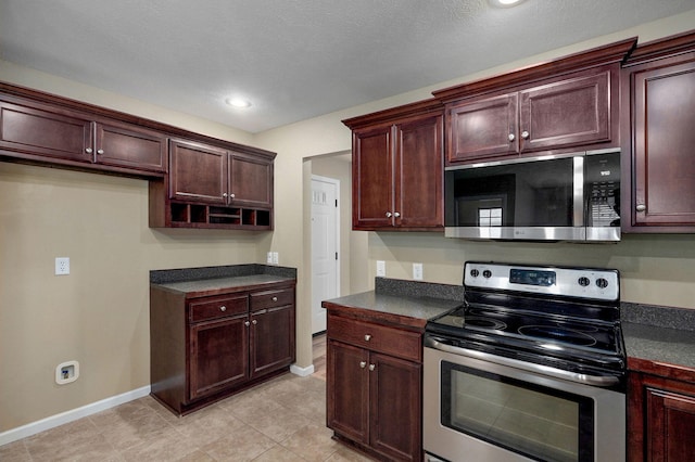 5834 Geranium Ln, Battlefield, MO 65619 - kitchen with appliances with stainless steel finishes, dark countertops, light tile patterned floors, and recessed lighting