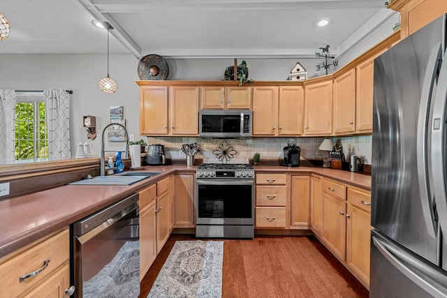 701 E Bayshore Dr, Ozark, MO 65721 - kitchen with appliances with stainless steel finishes, backsplash, wood finished floors, hanging light fixtures, and light brown cabinetry